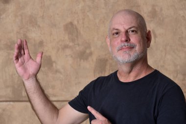 Yetişkin, beyaz sakallı, siyah giysili bir erkek model.