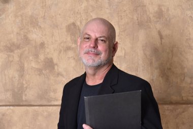 Yetişkin, beyaz sakallı, siyah giysili bir erkek model.