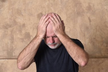 Yetişkin, beyaz sakallı, siyah giysili bir erkek model.