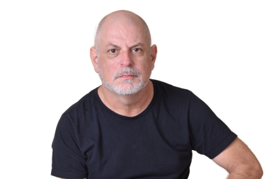 Siyah gömlekli, beyaz sakallı ve kel kafalı çekici bir adamın portresi.