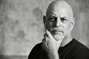 Portre yetişkin adam kel beyaz sakallı yüz ifadesi mutlu, siyah giysili, düşünceli bir erkek model..