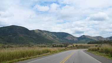 Mavi gökyüzü ile yol berrak gün asfaltlı otoyol çiftlik bitkileri dağlar bulutlar görüntü