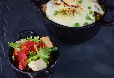 Domates soslu köfteler, erimiş peynir ve ekmek kızartmalı baharatlar.