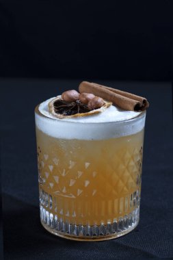 Turunçgil suyu, egzotik bir tabakta servis edilir. Buz ve kurutulmuş limon siyah arka planda izole edilir.