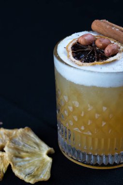 Turunçgil suyu, egzotik bir tabakta servis edilir. Buz ve kurutulmuş limon siyah arka planda izole edilir.