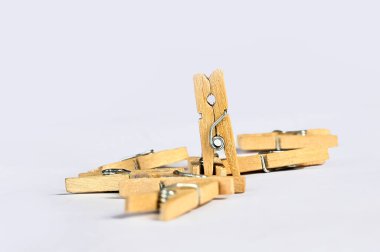 Çamaşır iğneleri beyaz arka planda ahşap doğal bambu mandallar asıyor..