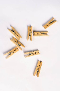 Çamaşır iğneleri beyaz arka planda ahşap doğal bambu mandallar asıyor..