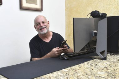 Yetişkin bir adam, ofisteki Tablet Yaşlılar için not defteri cep telefonu iletişim teknolojisi bilgisayarını kullanıyor