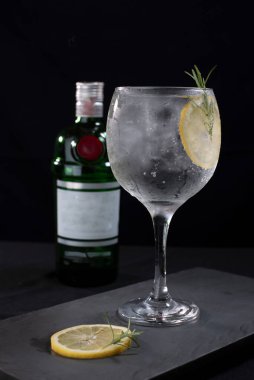 Meyveli ferahlatıcı alkollü içecek, soğuk votka ve cin, cam bardakta servis edilen limon kabuğu.