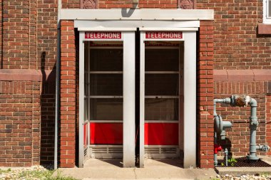 Tuğla binadaki eski telefon kulübeleri. Dixon, Illinois, ABD.