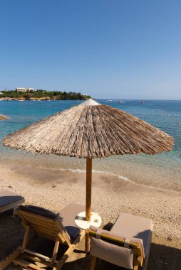 Agia Pelagia, Girit, Yunanistan 'ın arka planında okyanus bulunan Thatched tatil beldesi şemsiyesi.