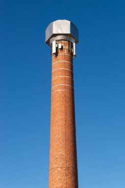 Arka planda mavi gökyüzü olan eski tuğla bacası. Lansing, Michigan, ABD.