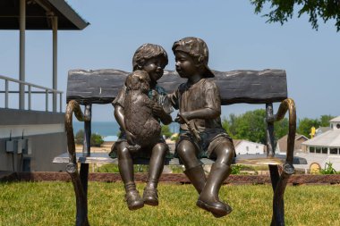 St. Joseph, Michigan - ABD - 20 Haziran 2023: St. Joseph, Michigan, ABD şehir merkezindeki bankta çocukların heykeli.