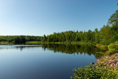 ABD 'nin Wisconsin eyaletindeki Pattison State Park' taki Interfalls Gölü 'nün sabah ışığı ve yansımaları..