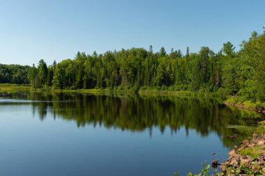 ABD 'nin Wisconsin eyaletindeki Pattison State Park' taki Interfalls Gölü 'nün sabah ışığı ve yansımaları..