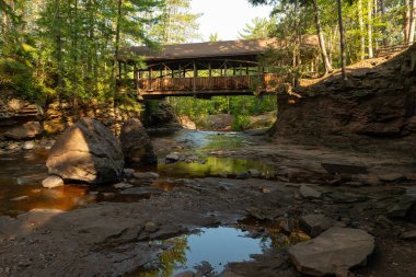 Wooden covered Bridge on a beautiful Summer morning at Amnicon Falls State Park in Wisconsin, USA. clipart