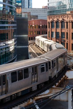 Chicago, Illinois - ABD - 6 Nisan 2025: Chicago, Illinois, ABD 'de şehir merkezindeki binalardan geçen banliyö treni.