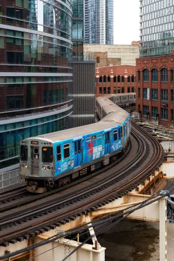 Chicago, Illinois - ABD - 5 Nisan 2025: Chicago, Illinois, ABD 'de şehir merkezindeki binalardan geçen banliyö treni.