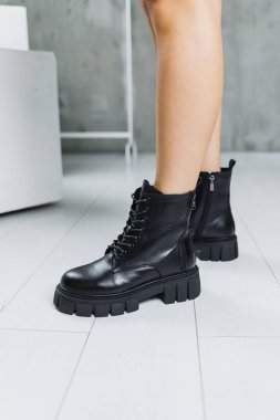 Siyah deri çizmeli, ince kadın bacakları. Modaya uygun kadın çizmeleri. Kadın deri ayakkabıları..