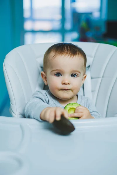 可愛い赤ちゃんがアボカドを食べる 小さな子供のためのビタミンや健康食品 8ヶ月の美しい子供の肖像画 — ストック写真
