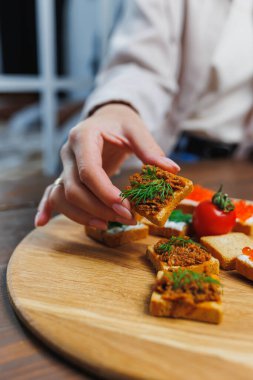 Kızarmış ekmek dilimleri ve kadın ellerinde ezme. Tahıl unundan yapılmış taze kızarmış ekmekler.