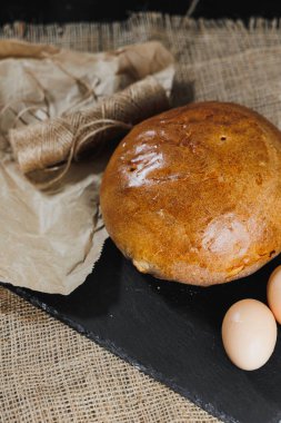 Ev yapımı ekmek, doğal tarım ürünleri. Sağlıklı ve lezzetli hamur işleri. Tam tahıllı ekmek, yumurta, un. Kapat, koyu arkaplan