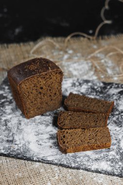 Tam tahıllı çavdar ekmeği dilimleri. Koyu bir arka planda. Yakın plan. Taze ev yapımı ekşi ekmek.
