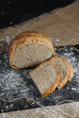 Tam tahıllı çavdar ekmeği dilimleri. Koyu bir arka planda. Yakın plan. Taze ev yapımı ekşi ekmek.