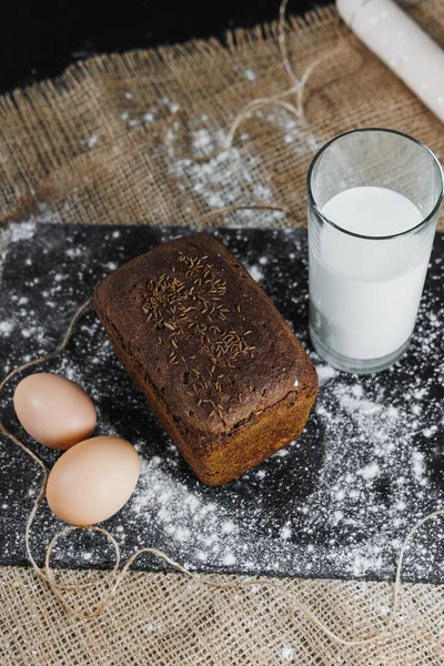 美味的圆形黑麦面包 有牛奶和鸡蛋 背景深色 脆新鲜面包 — 图库照片