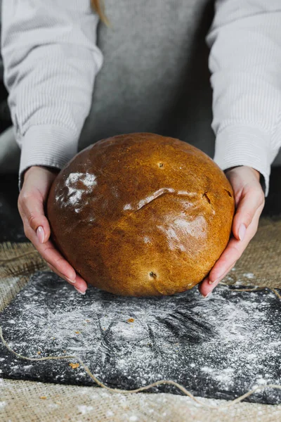 Ev yapımı çıtır ekmek. Baker 'ın elinde taze ekmek var. Koyu arkaplan