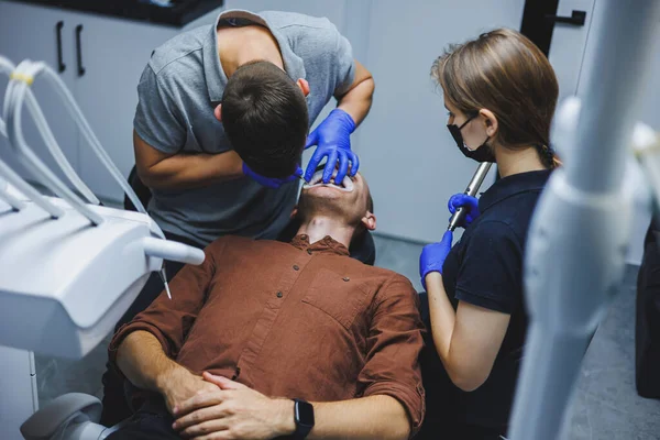 Лечение Зубов Молодой Человек Приеме Дантиста Врач Ассистент Лечат Зубы — стоковое фото