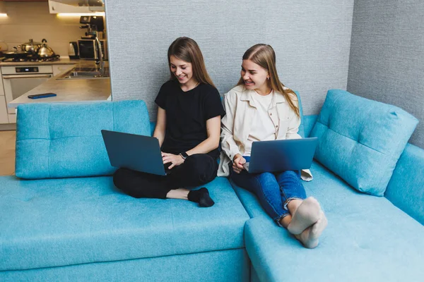 stock image Two cute women working using laptop in living room on sofa. Friends, friendship, time together. Girlfriends are sitting on the couch and watching a movie