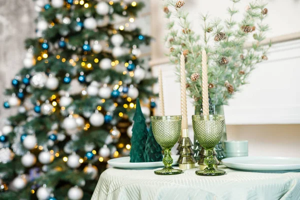 stock image The table is set near the Christmas tree for a romantic New Year's dinner. New Year's festive dinner.