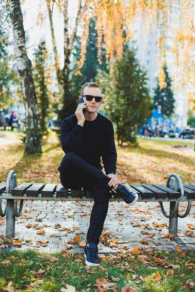 스웨터를 외로운 젊은이 공원에 벤치에 전화로 이야기를 — 스톡 사진