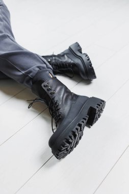 Kadınların bacaklarında siyah deri çizmeler. Sıcak kış kadın ayakkabıları koleksiyonu