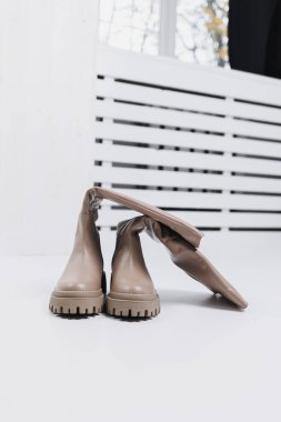 Yerde bej çizmeler var. Kış bej kadın ayakkabıları..