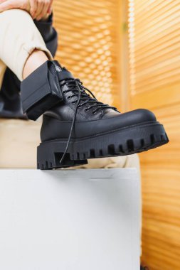 Siyah deri çizmeli kadın bacaklarının yakın çekimi. Kadın kış ayakkabıları. Kadın deri ayakkabılarının yeni sonbahar koleksiyonu