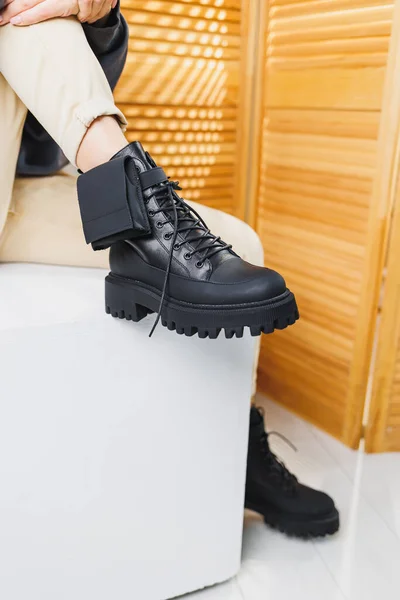 stock image Close-up of female legs in black leather lace-up boots. Women's winter shoes. New autumn collection of women's leather shoes