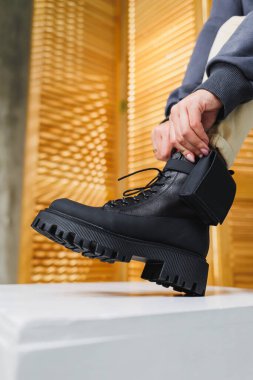 Kadınların bacaklarında siyah deri çizmeler. Sıcak kış kadın ayakkabıları koleksiyonu