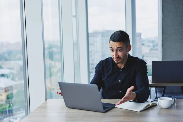 一位白种人的成功商人身穿黑色衬衫 坐在办公桌前 在现代化的办公室里使用笔记本电脑 办公室的工作气氛 — 图库照片