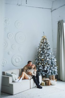 Noel arifesinde birbirine aşık bir çift Noel ağacının yanında rahat bir ev ortamında. Yeni yılın aşk hikayesi. Stüdyoda poz veren kazaklı güzel bir çift. Bir erkek ve bir kız yeni yılı kutluyorlar.