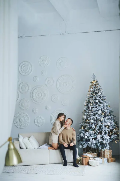 A beautiful couple embraces during a New Year\'s photo session. Lovers welcome the new year together. A couple in love enjoying each other on New Year\'s Eve. New Year and Christmas. February 14th.