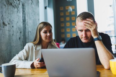 Pozitif genç iş arkadaşları masada oturup laptopa bakıp gülüyorlar. Takım çalışması konsepti. Seçici odaklanma. Modern başarılı insanlar