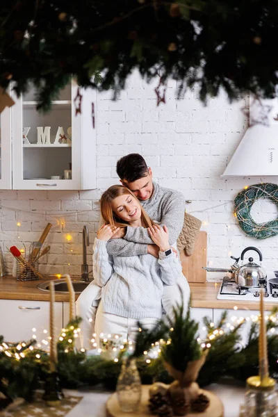 一对快乐的年轻夫妇拥抱在厨房里 为新年装饰一番 厨房里的新年室内 圣诞厨房 — 图库照片
