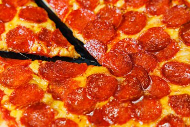 Sosisli dilimlenmiş pizza, domates sosu, mozzarella, soğan ve hamur kenarlı siyah arka planda krem peynirli.