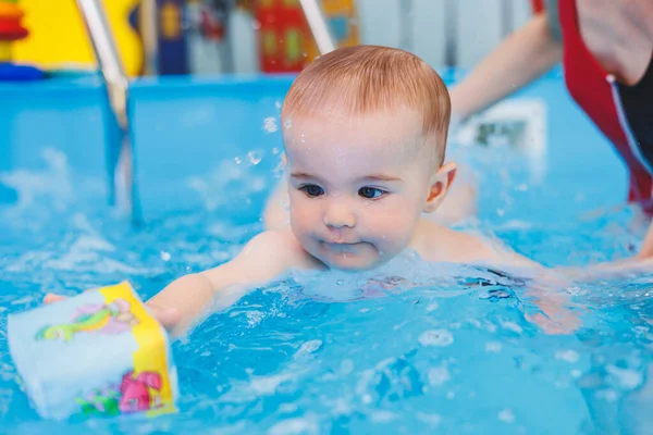 stock image A little boy is learning to swim in a baby pool. Children's development. First swimming lessons for children