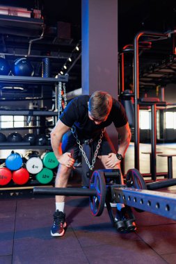 Yakışıklı kaslı adam spor salonunda ağır egzersizler yapıyor. Sağlıklı yaşam tarzı