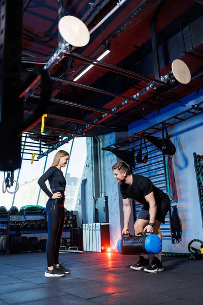 A trainer shows an exercise for a woman in a gym. Exercise in the gym with a trainer.