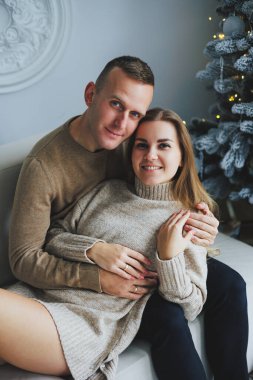 Mutlu bir çift, Noel ağacının yanında oyuncaklar ve çelenklerle süslenmiş bir şekilde yeni yılı kutluyor. Sevgililer yeni yıla hoş geldiniz der. Yeni yıl ve Noel konsepti. 14 Şubat.