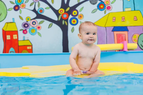 Swimming lessons for children. A little boy is learning to swim in a baby pool. Children\'s development. First swimming lessons for children